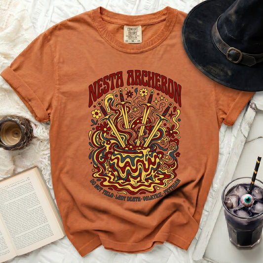 Orange t-shirt with "Nesta Archeron" text and cauldron with swords graphic.