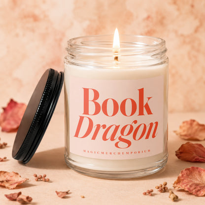 Lit candle in a glass jar with "Book Dragon magicmerchemporium" text on label.