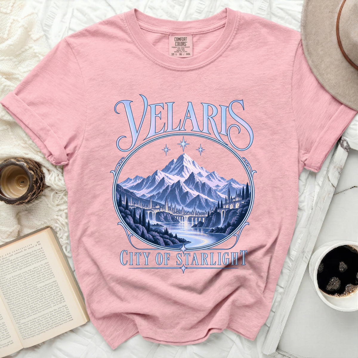 Pink t-shirt with "Velaris City of Starlight" text and mountain landscape design.