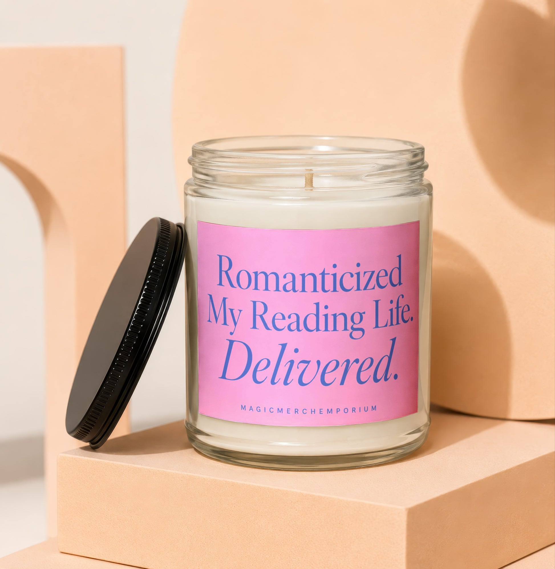 Glass jar candle with pink label saying "Romanticized My Reading Life. Delivered."