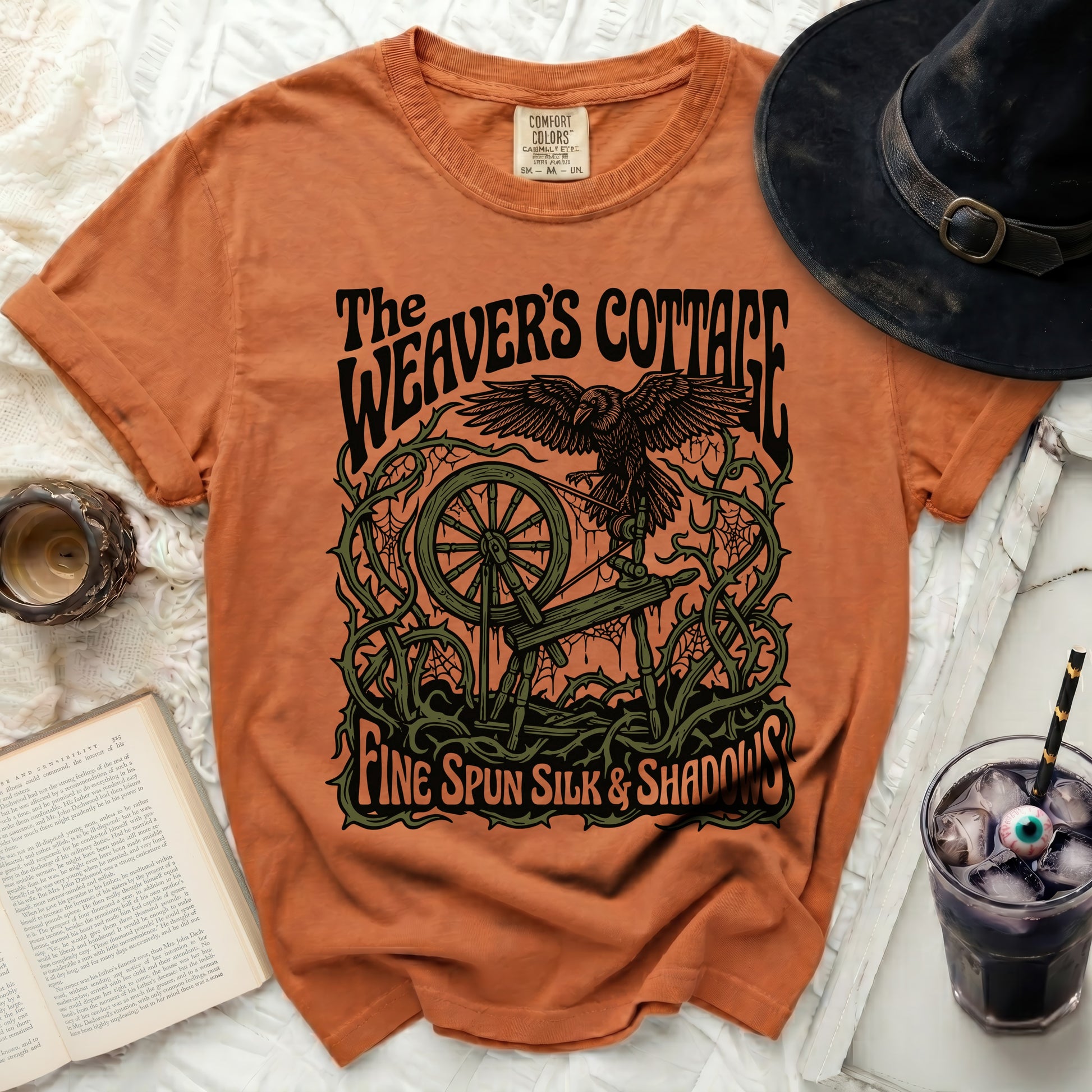 The Weaver's Cottage t-shirt with a raven, spinning wheel, and text.