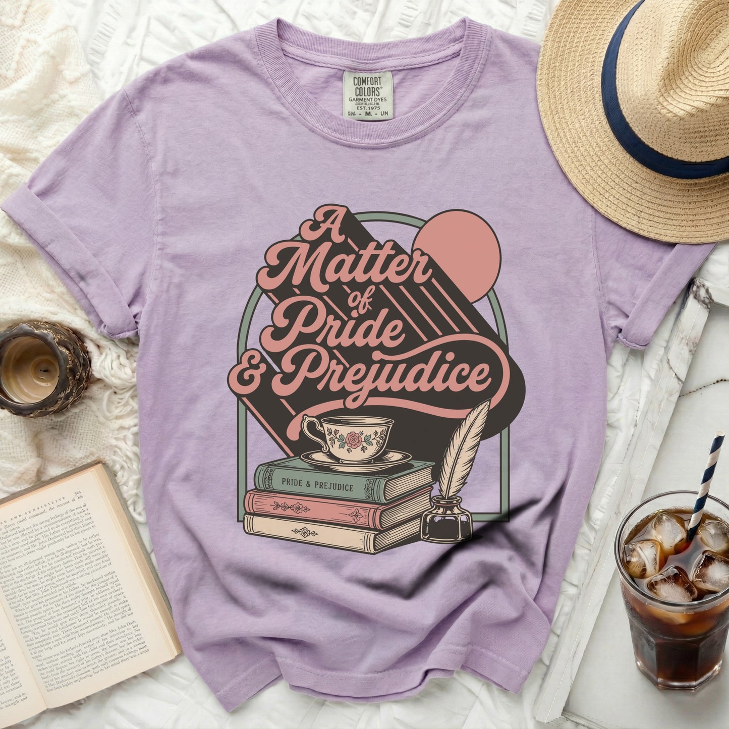 Lavender t-shirt with "A Matter of Pride & Prejudice" graphic and books.