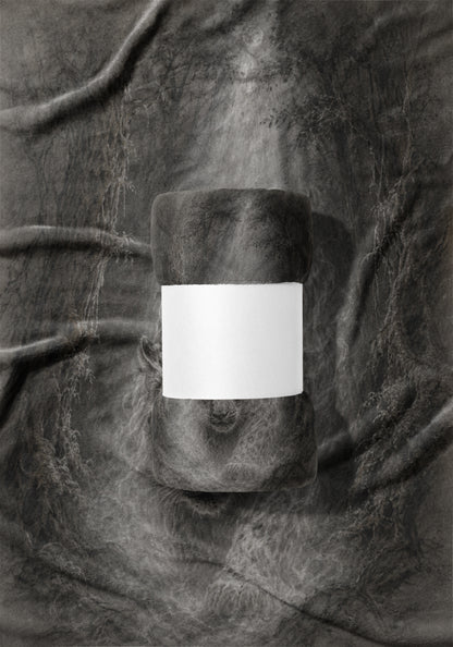 Rolled fleece blanket with blank white band on a textured gray fabric background.
