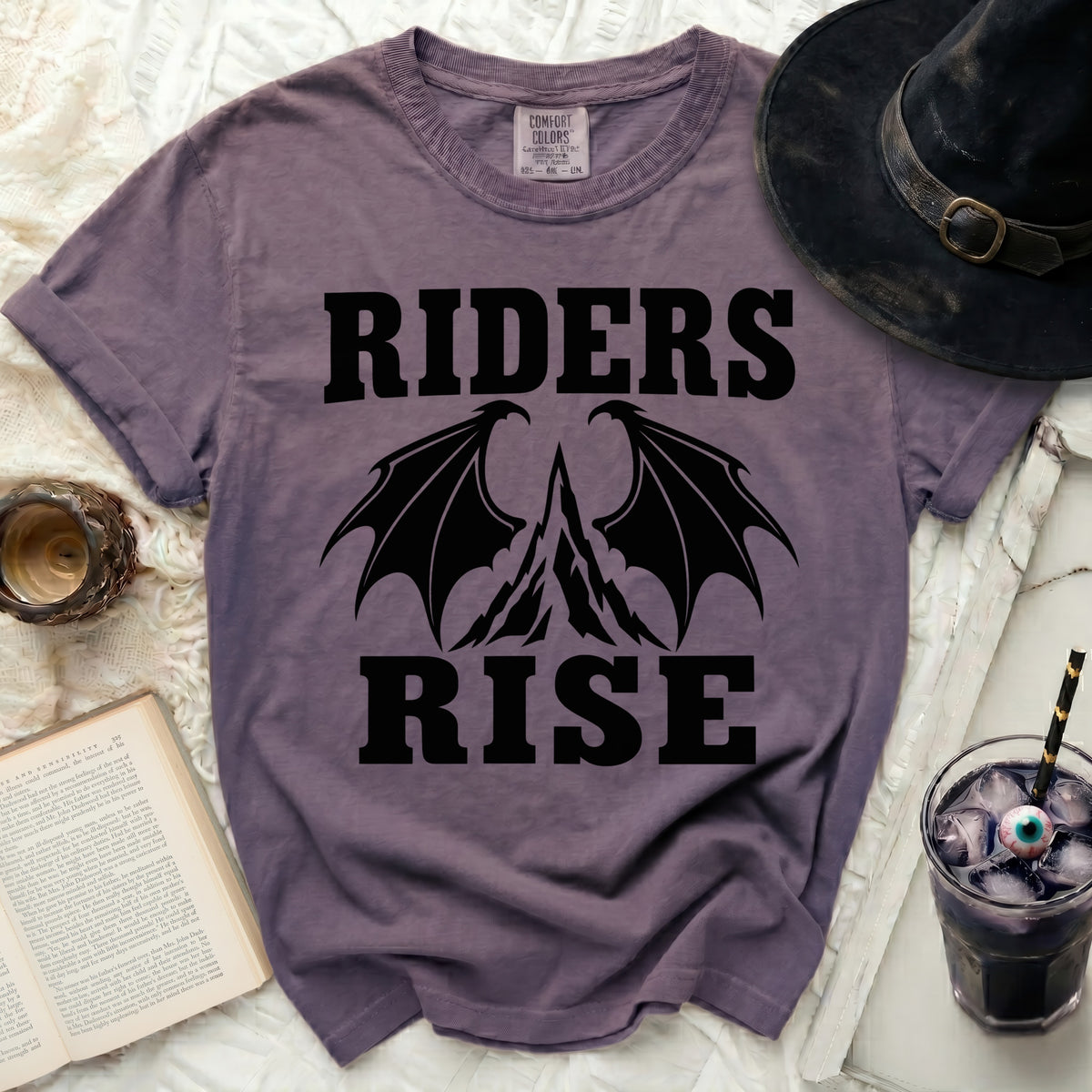 Purple t-shirt with black text "RIDERS RISE" and dragon wings graphic.