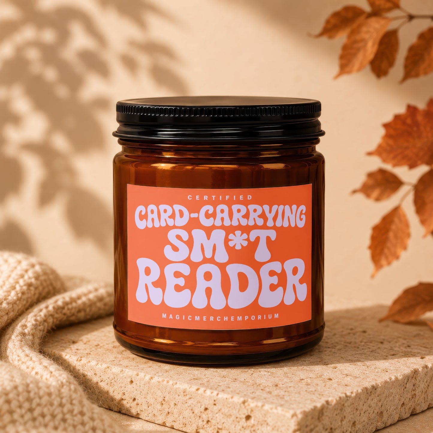 Amber jar candle with "Certified Card-Carrying Sm*t Reader" on an orange label.