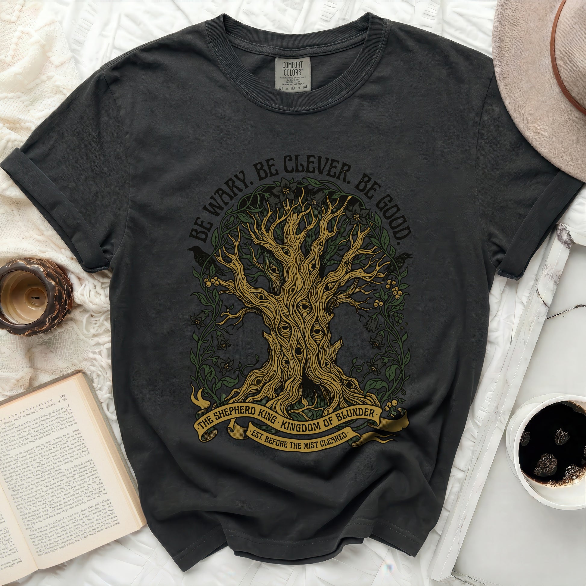 Dark t-shirt with tree graphic and text "BE WARY. BE CLEVER. BE GOOD."