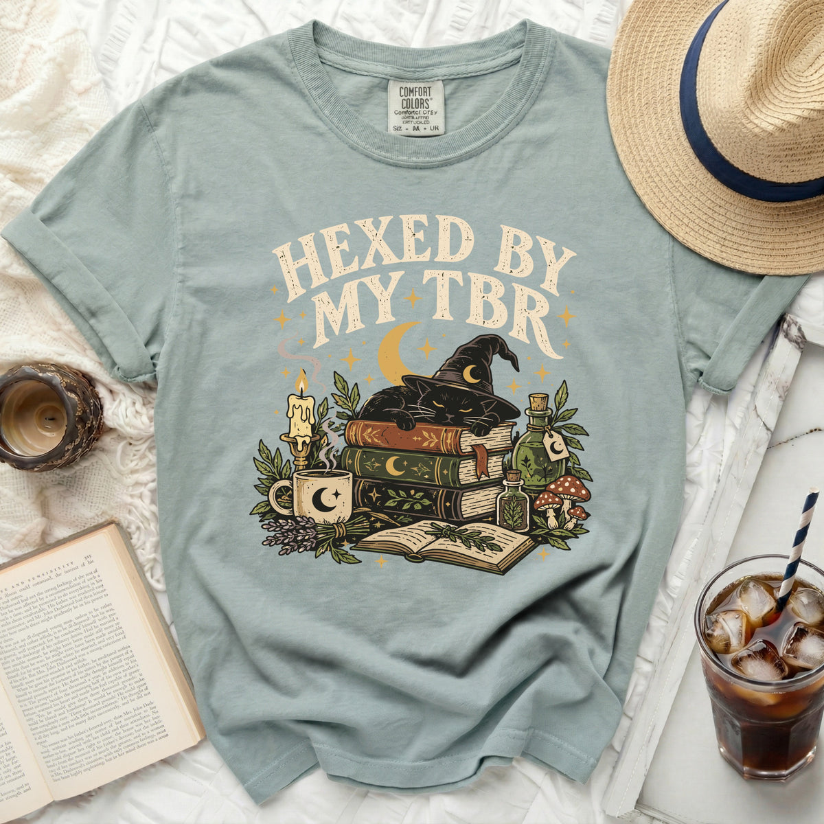 T-shirt with "Hexed by my TBR" text, black cat, books, and witchy elements.