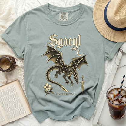 Sgaeyl text graphic on a t-shirt with dragon, dagger, and flower designs.