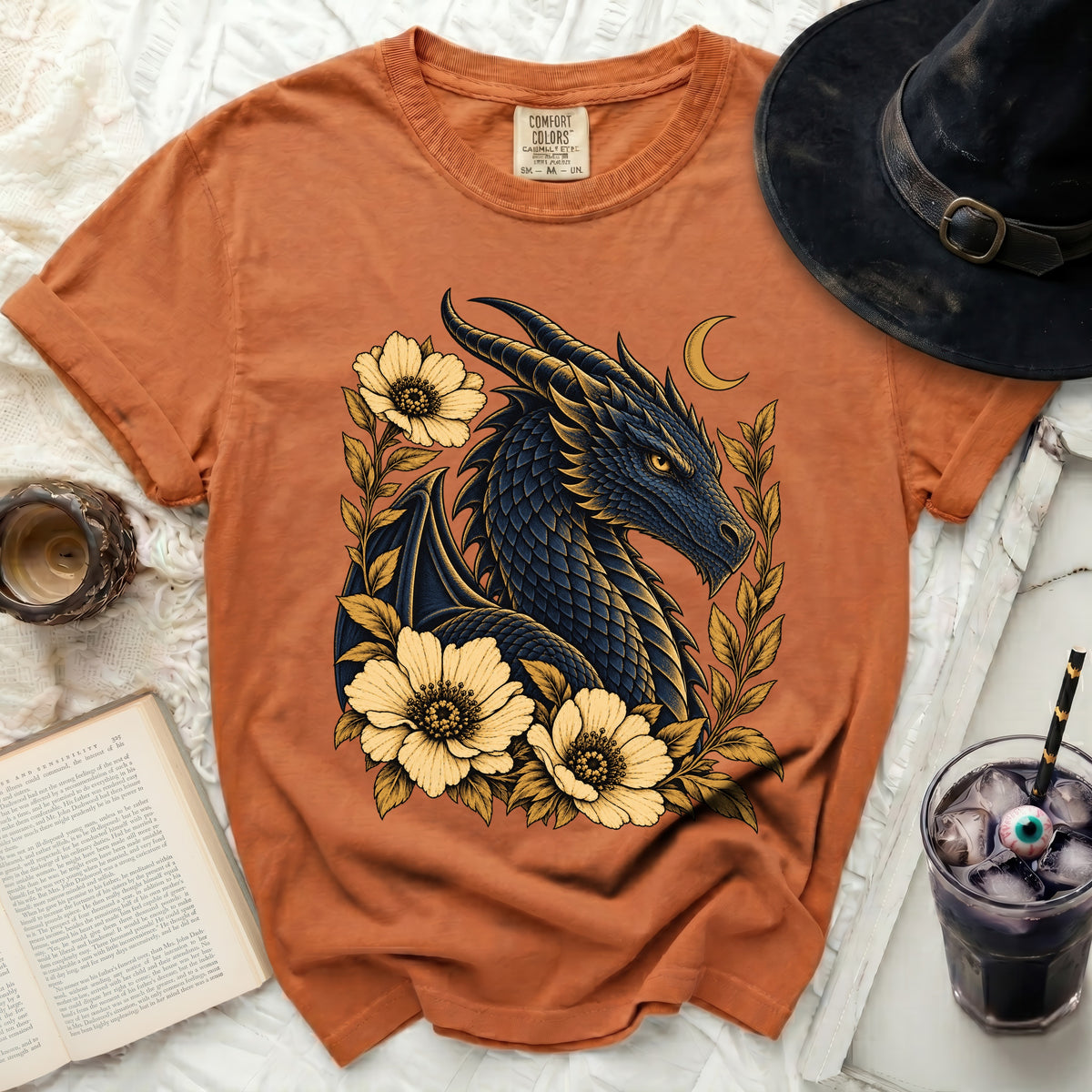 Orange t-shirt with a dark blue dragon, yellow flowers, and crescent moon graphic.