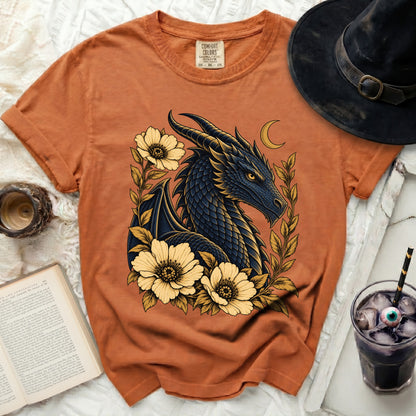 Orange t-shirt with a dark blue dragon, yellow flowers, and crescent moon graphic.