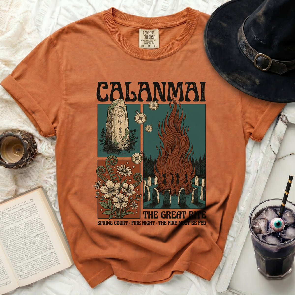 Orange t-shirt with CALANMAI The Great Rite graphic featuring stone monument, campfire, and flowers.