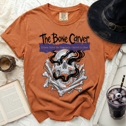 Orange t-shirt with "The Bone Carver" design featuring a skull and bones.