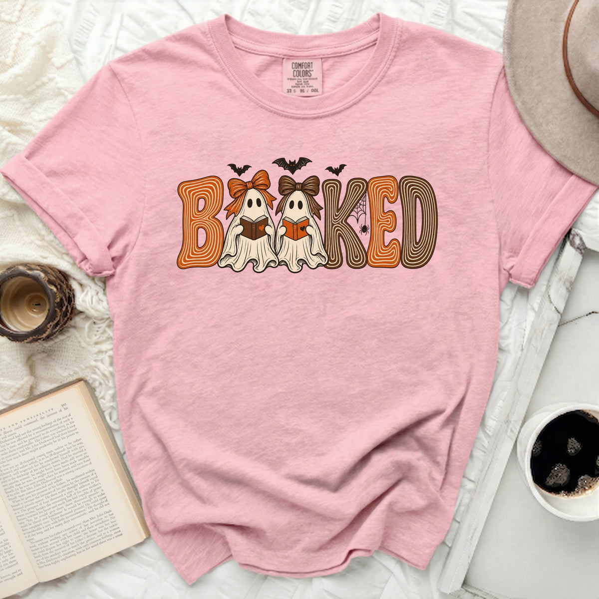 Pink t-shirt with "BAKED" graphic featuring ghosts reading books and bats.