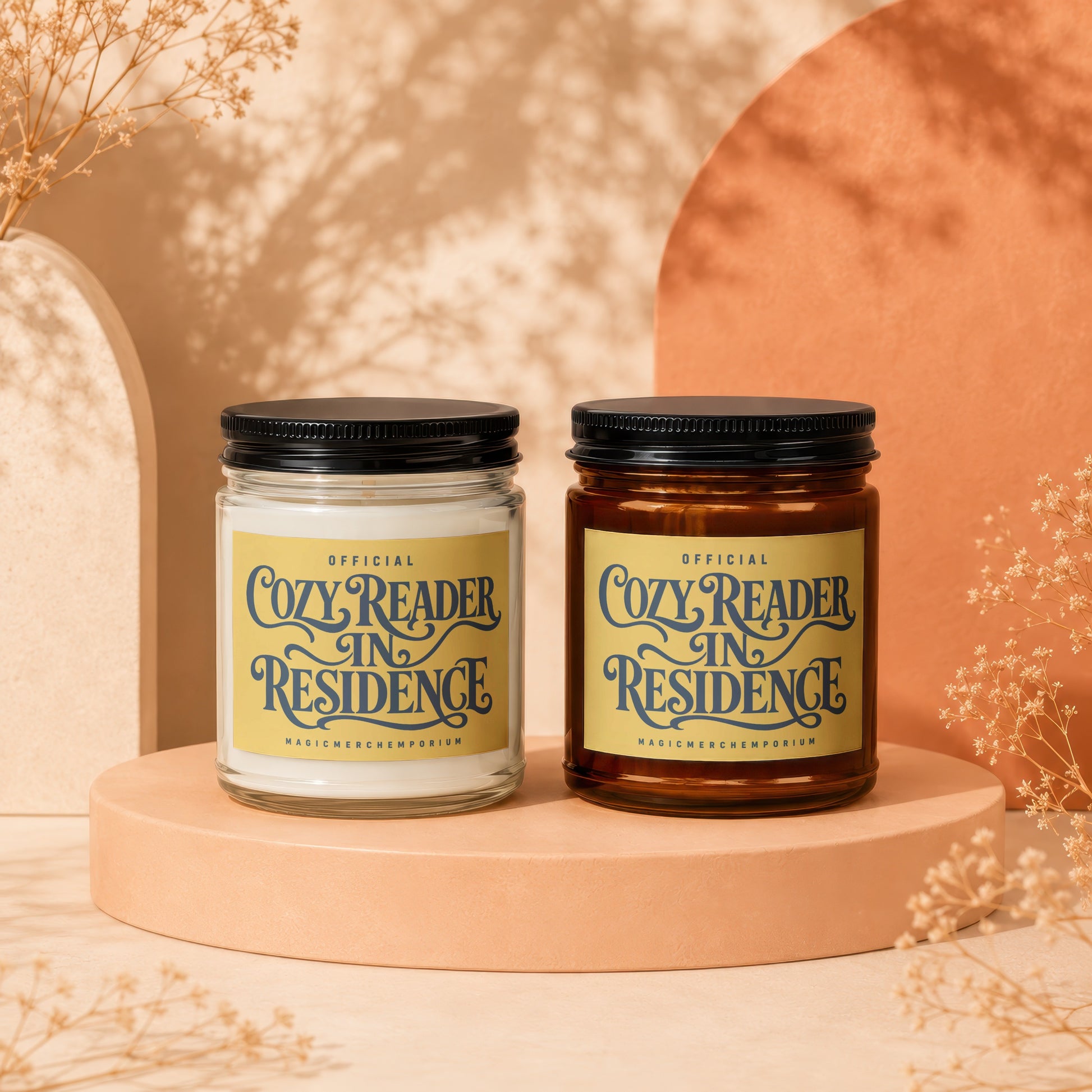 Two candles with "Cozy Reader In Residence" labels on a display stand.