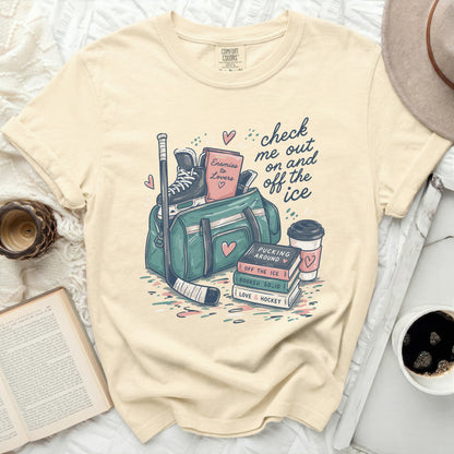 T-shirt with hockey bag, skates, books, and coffee, reading "check me out on and off the ice."