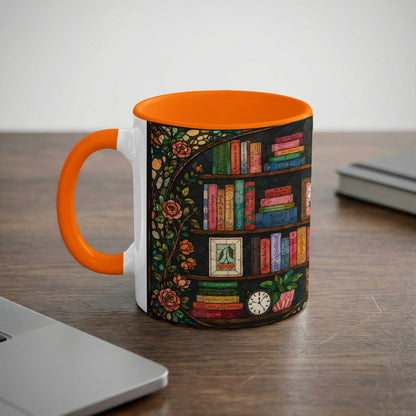 White mug with orange handle, decorated with stained glass books and roses.