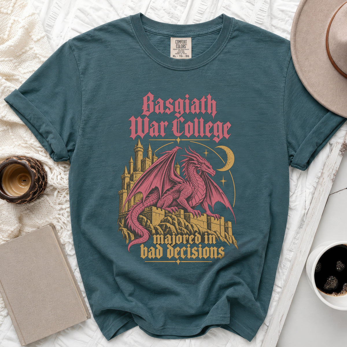 Teal t-shirt with pink dragon and castle graphic reading "Basgiath War College majored in bad decisions."