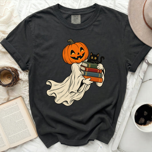 Ghost with pumpkin head holding books and a cat graphic on a dark t-shirt.