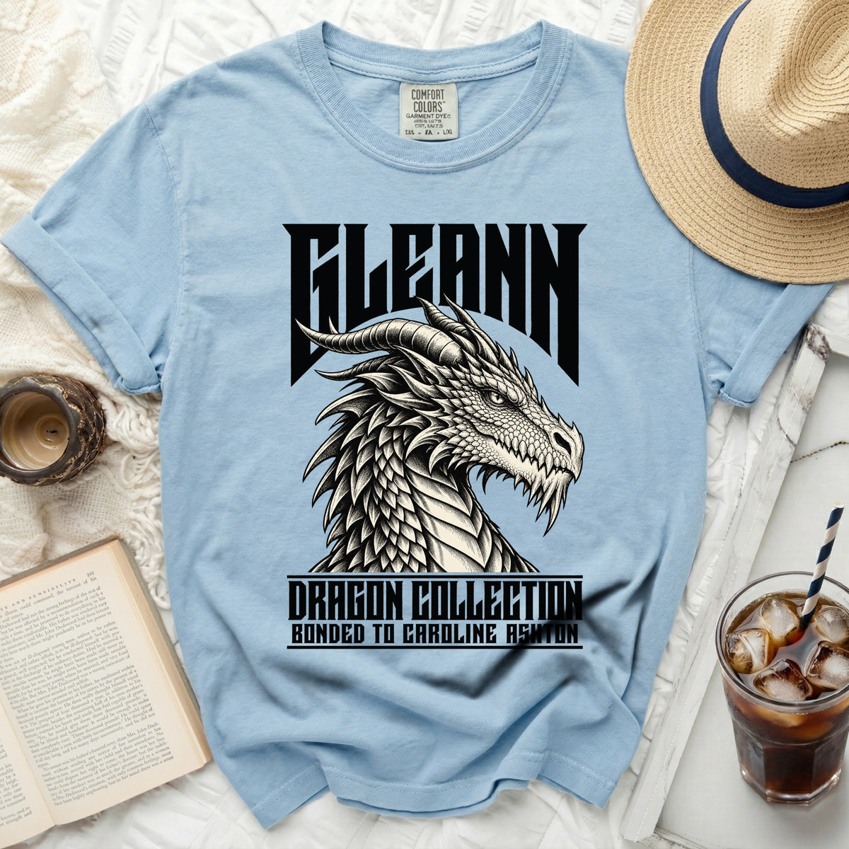 Light blue t-shirt with black dragon graphic and text "FLEANN DRAGON COLLECTION BONDED TO CAROLINE ASHTON".