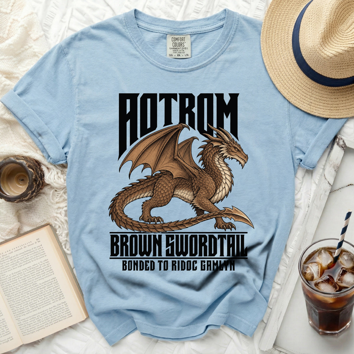 Light blue t-shirt with a brown dragon graphic and text "AOTROM BROWN SWORDTAIL BONDED TO RIDOC GAMLYN".