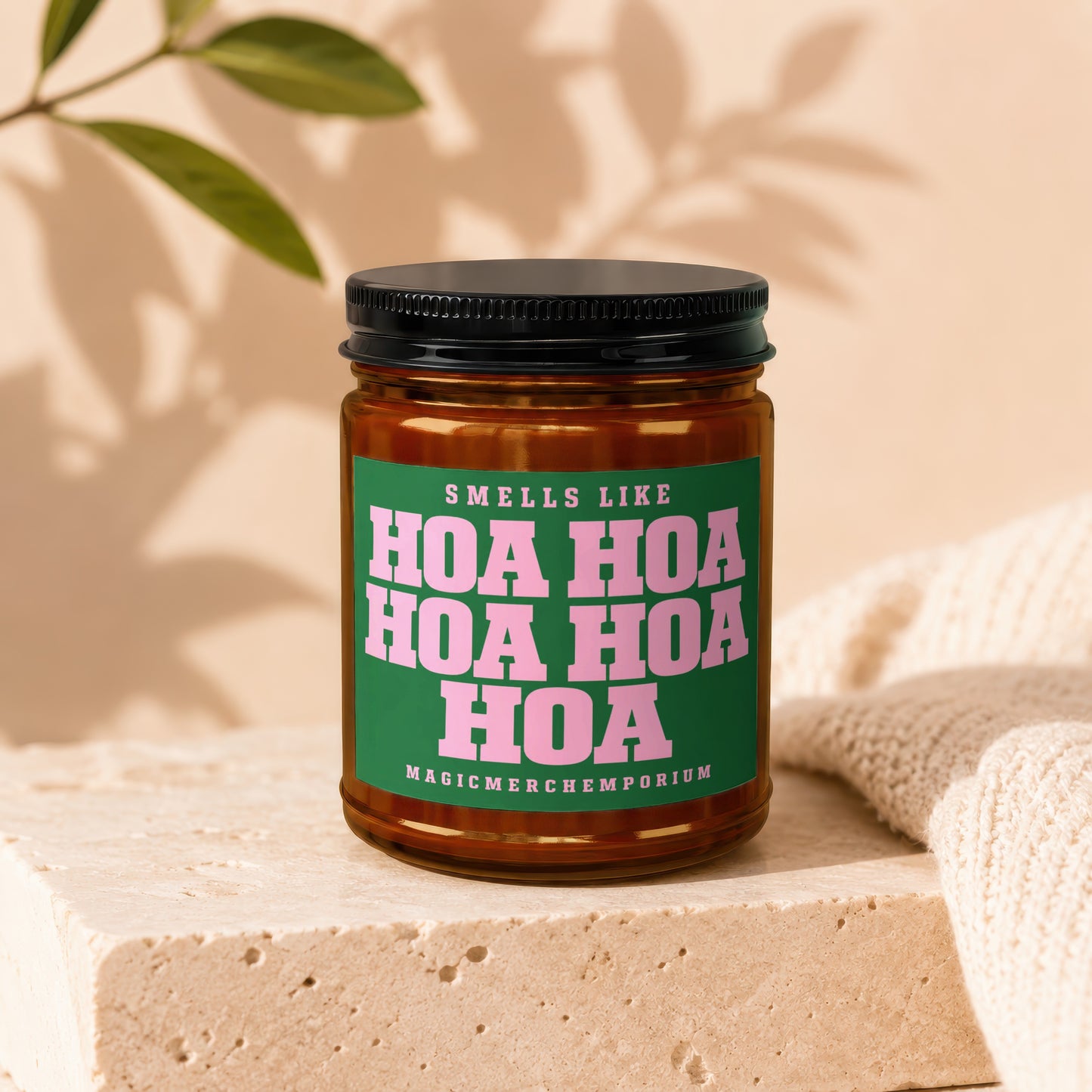Amber jar candle with green label reading "Smells Like Hoa Hoa Hoa Hoa Hoa Magicmerchemporium"