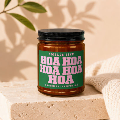 Amber jar candle with green label reading "Smells Like Hoa Hoa Hoa Hoa Hoa Magicmerchemporium"