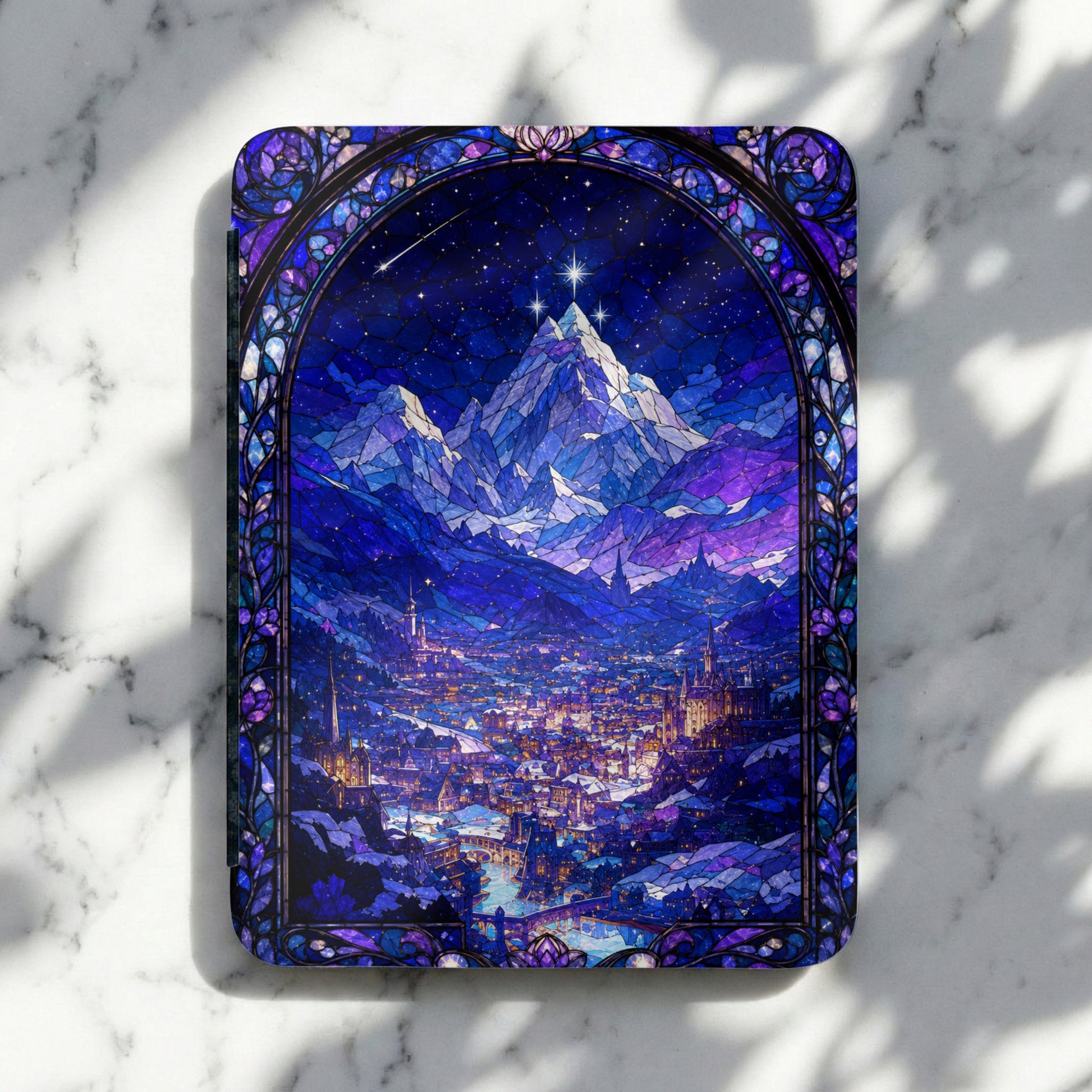 Stained glass window of a snowy city at night with mountains under a starry sky.