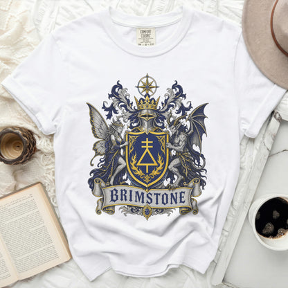 White t-shirt with a blue and gold crest featuring a fairy, a dragon, and the word BRIMSTONE.