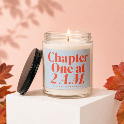 Glass candle with burning wick, "Chapter One at 2 A.M." text, and black lid.