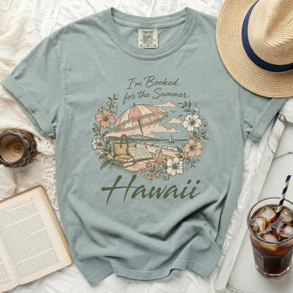 T-shirt with floral Hawaii and beach umbrella graphic and text.