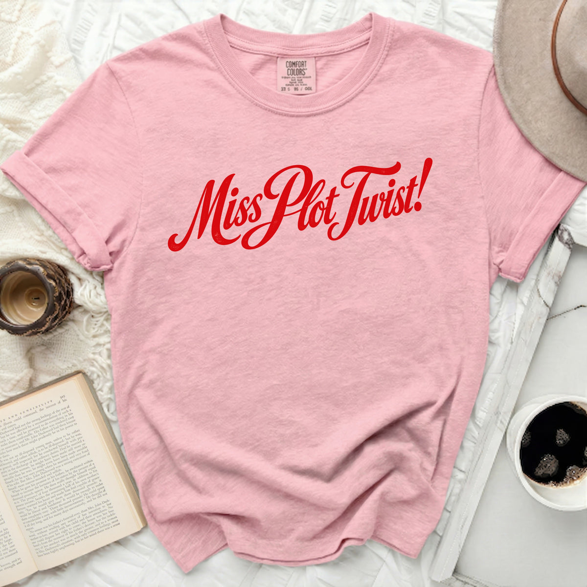 Pink t-shirt with red "Miss Plot Twist!" graphic and Comfort Colors tag.