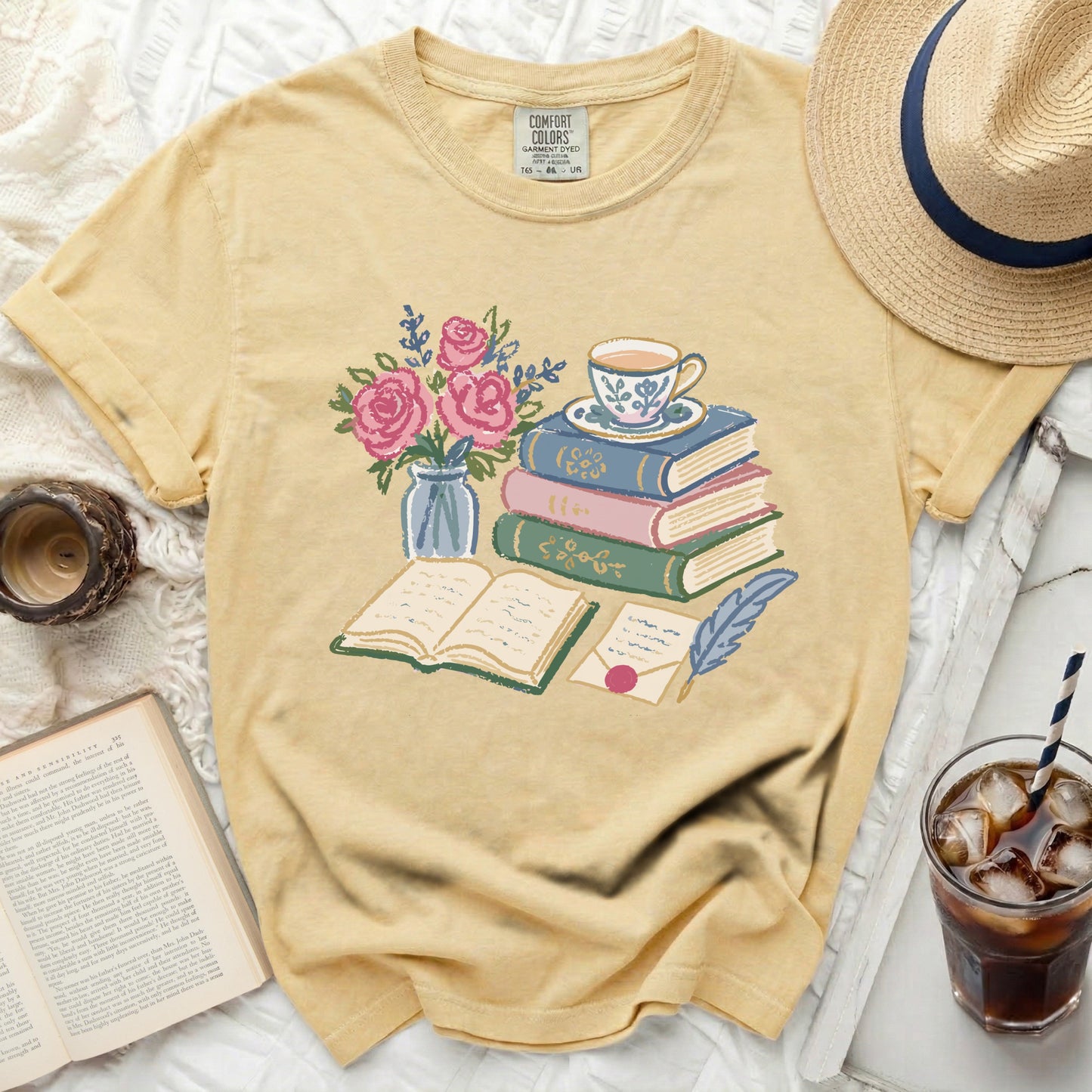 Yellow shirt with a faded print of books, roses, teacup, and quill pen.