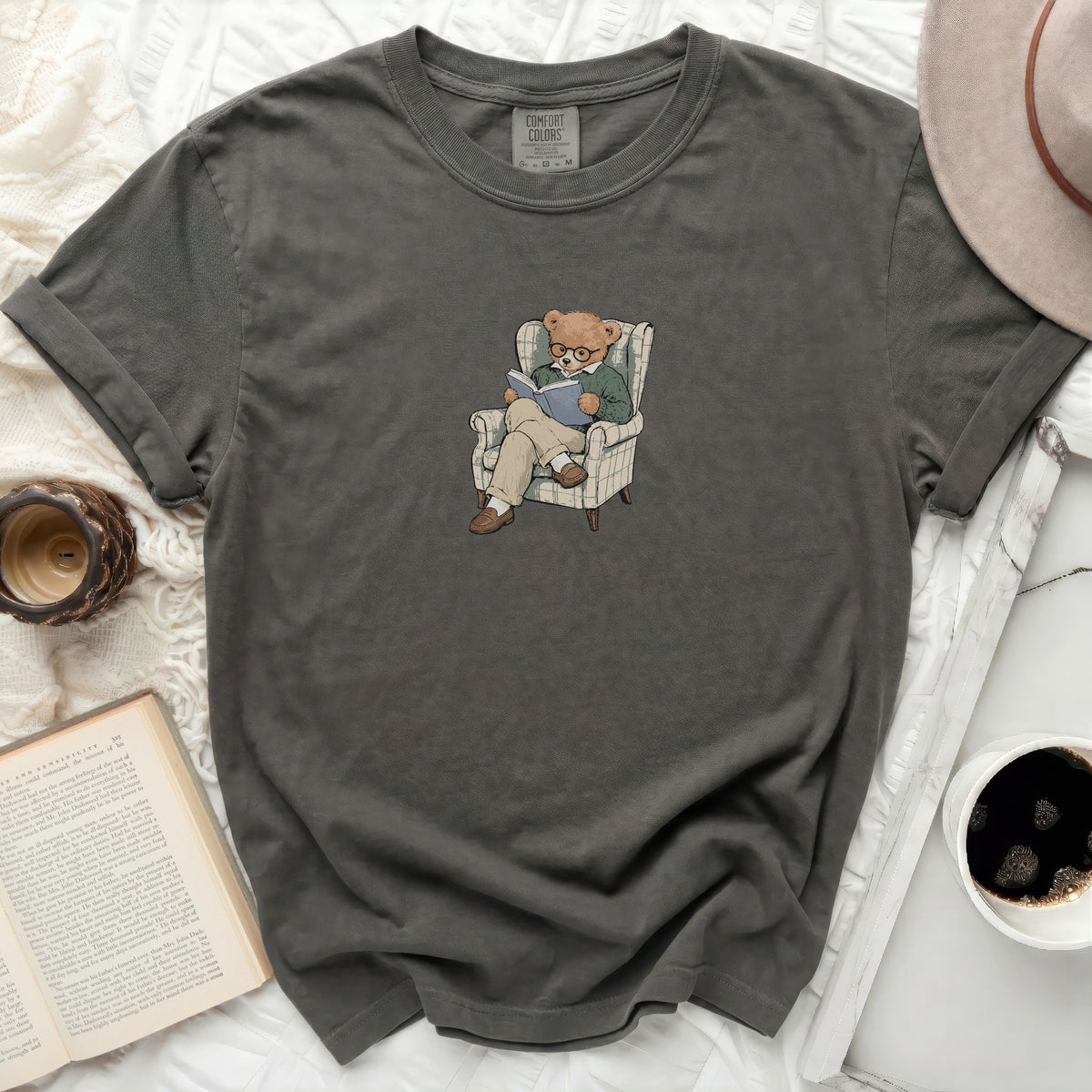 Graphic t-shirt with a bear reading in an armchair print.