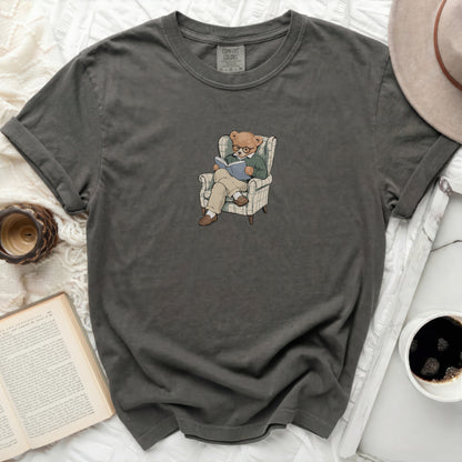 Graphic t-shirt with a bear reading in an armchair print.