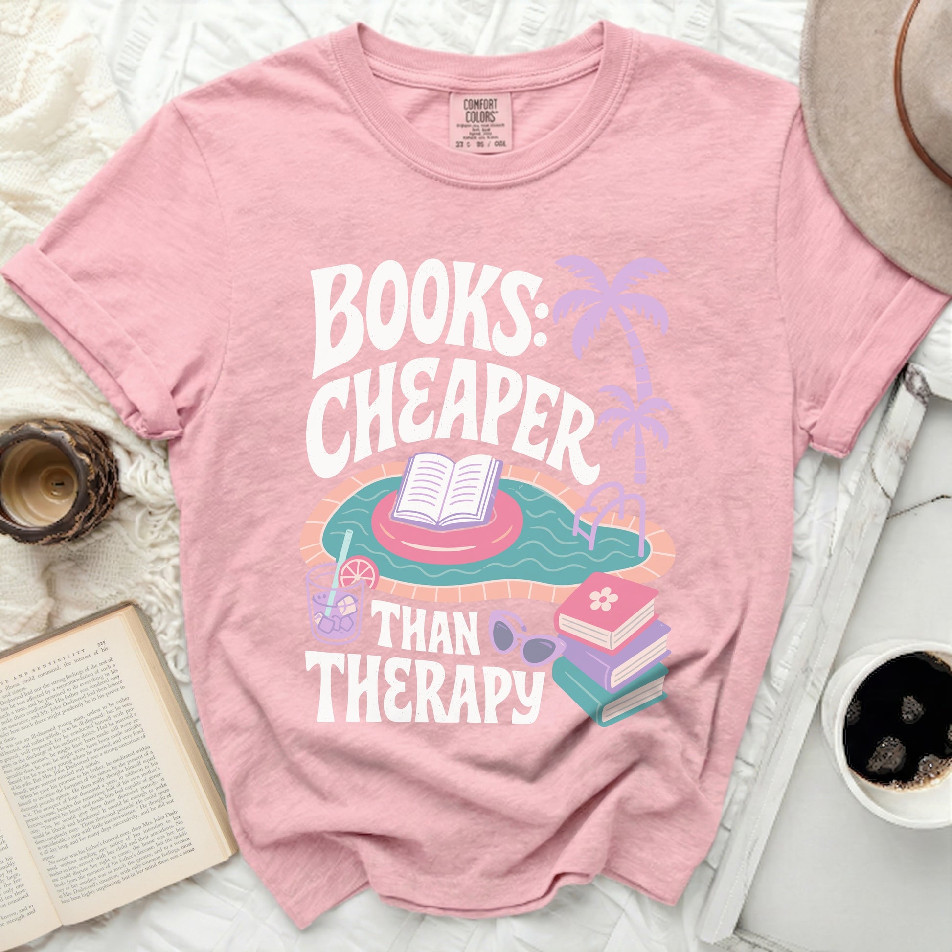 Pink t-shirt with "Books: Cheaper Than Therapy" text and swimming pool graphic.