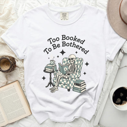 Skeleton reading a book with text "Too Booked To Be Bothered".