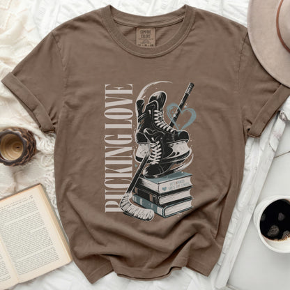 Brown t-shirt with "PUCKING LOVE" text and hockey skates on books.
