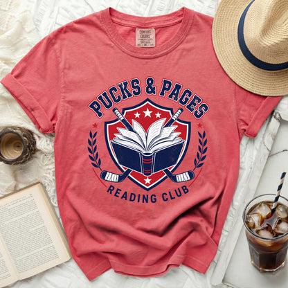 Red t-shirt with "Pucks & Pages Reading Club" text and hockey imagery.