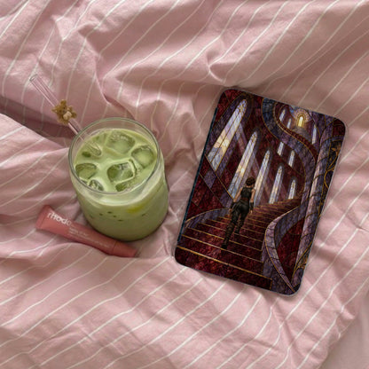 Green drink and makeup tube next to a phone case with a woman on a staircase.