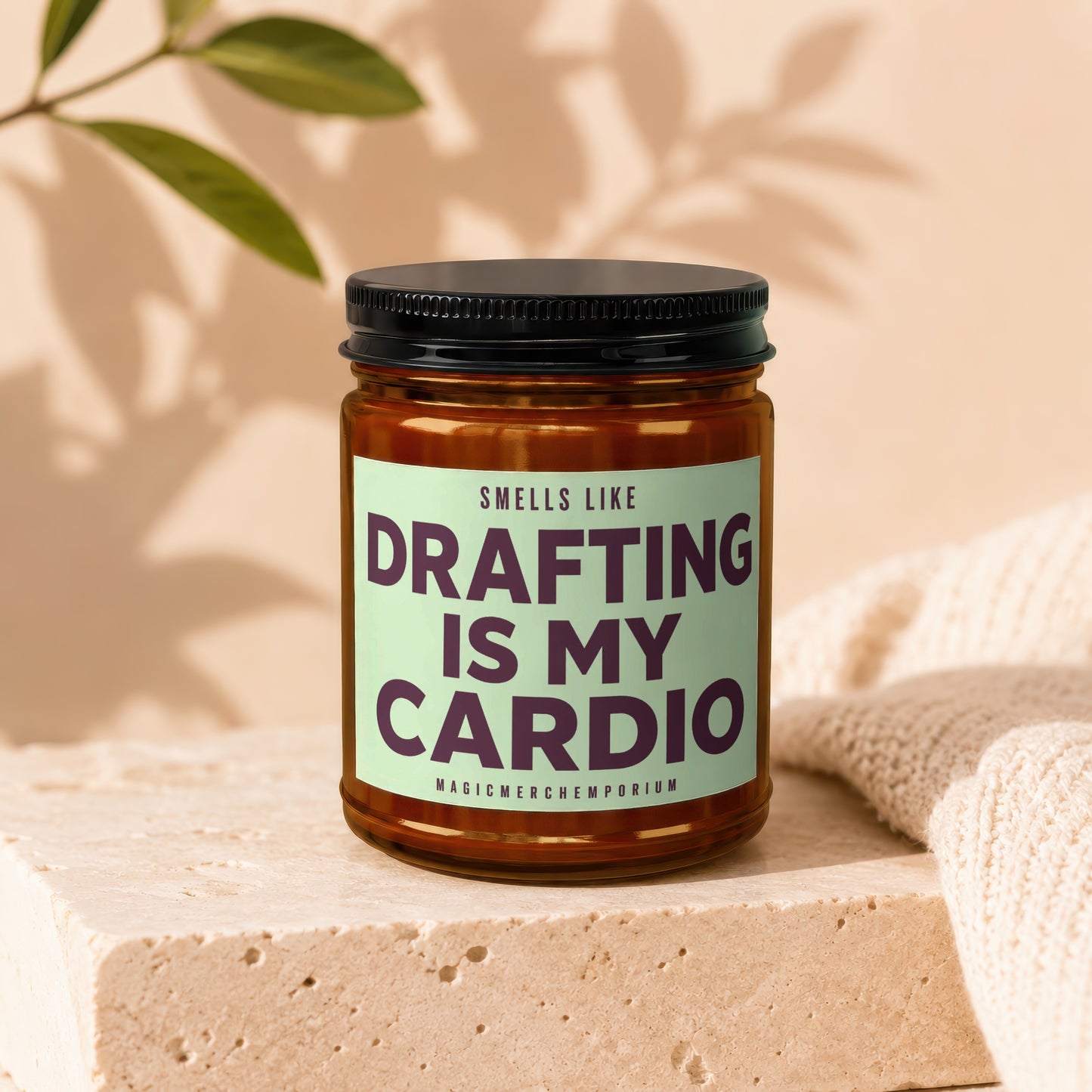 Amber jar candle with black lid reads: Smells Like Drafting Is My Cardio.