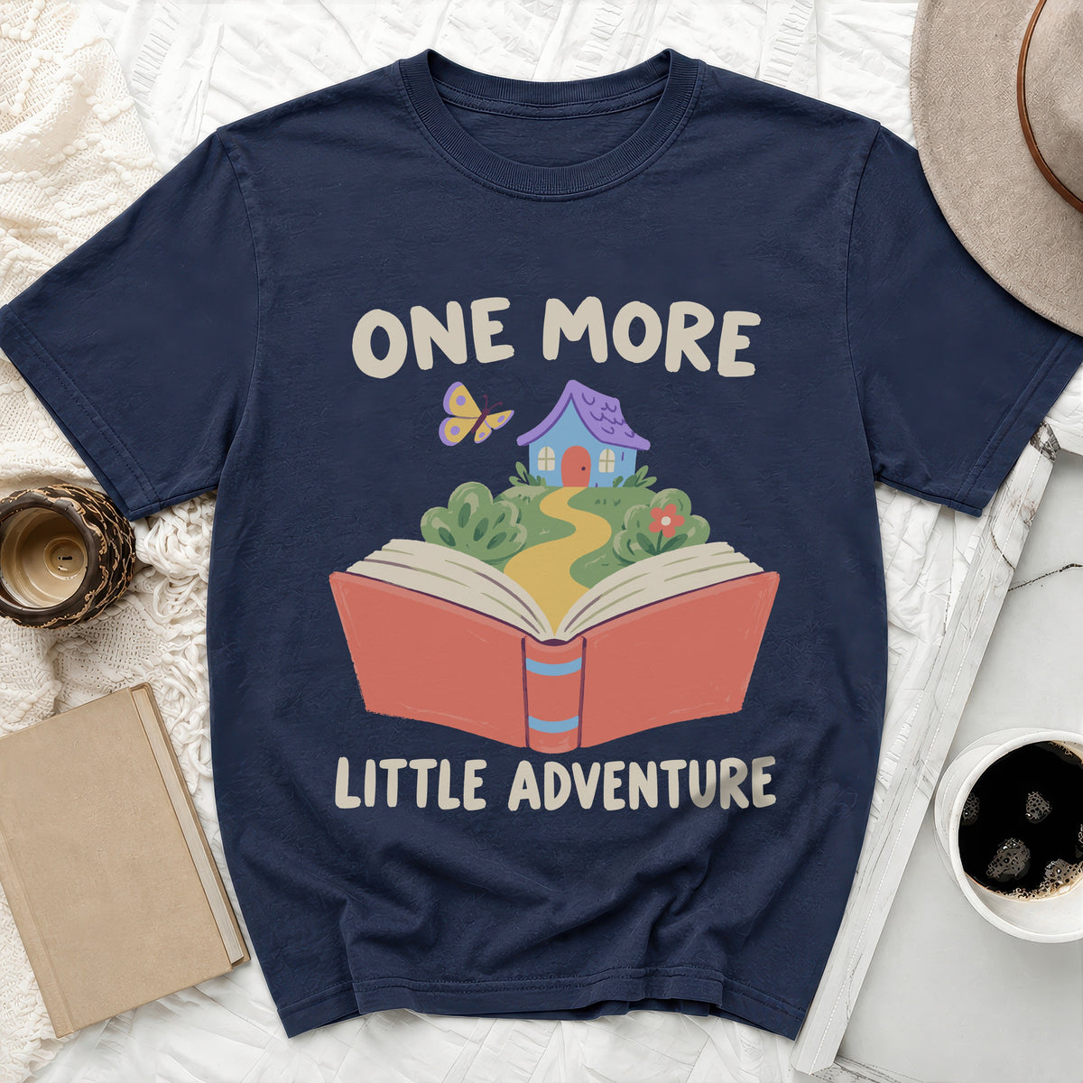 Navy t-shirt with "ONE MORE LITTLE ADVENTURE" text and book illustration.