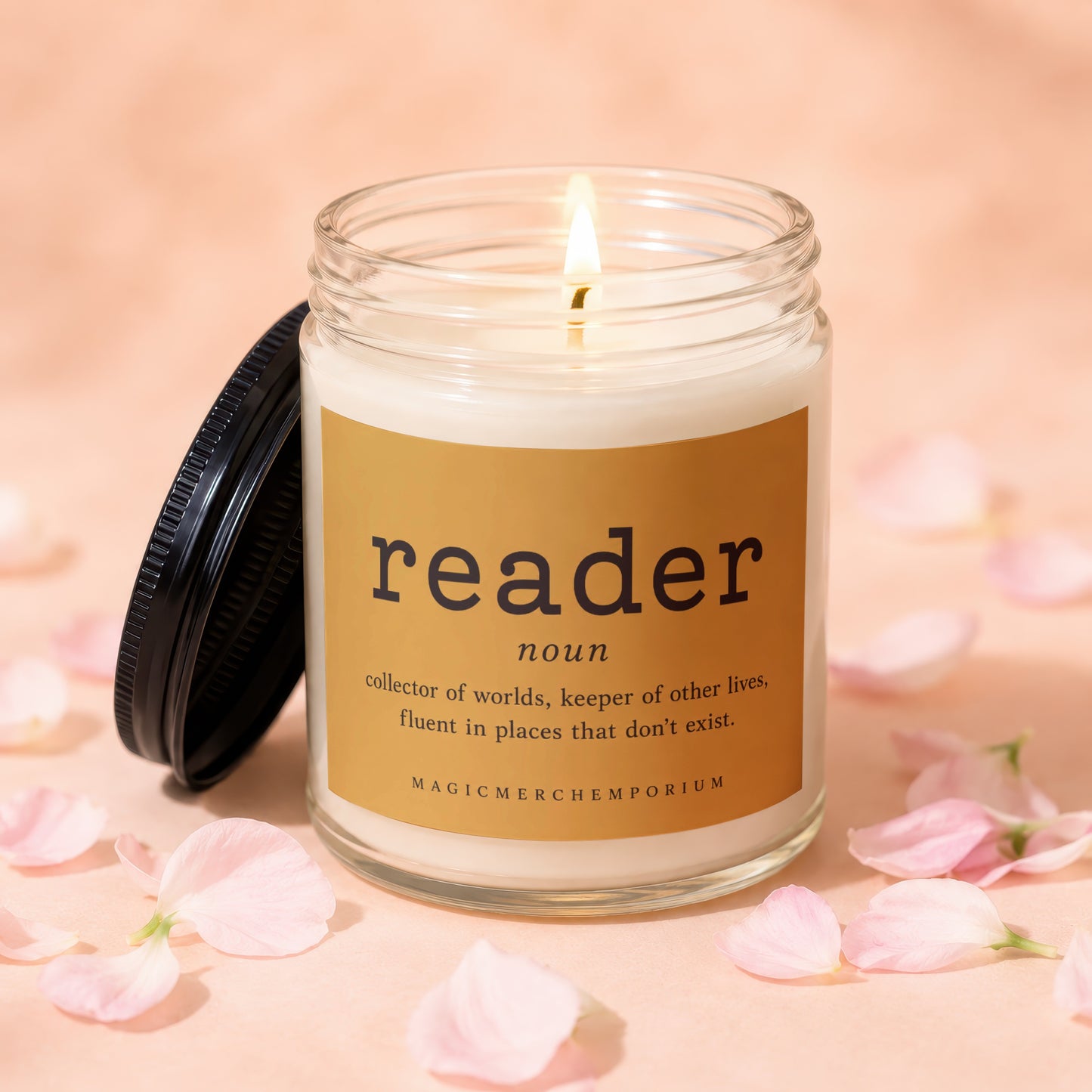 Candle with label "reader noun collector of worlds, keeper of other lives, fluent in places that don't exist."