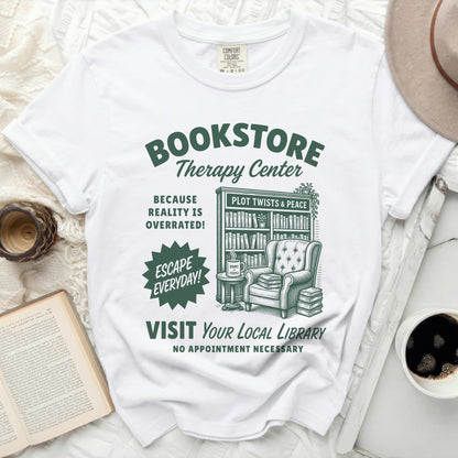 White t-shirt with "Bookstore Therapy Center" graphic and library imagery.