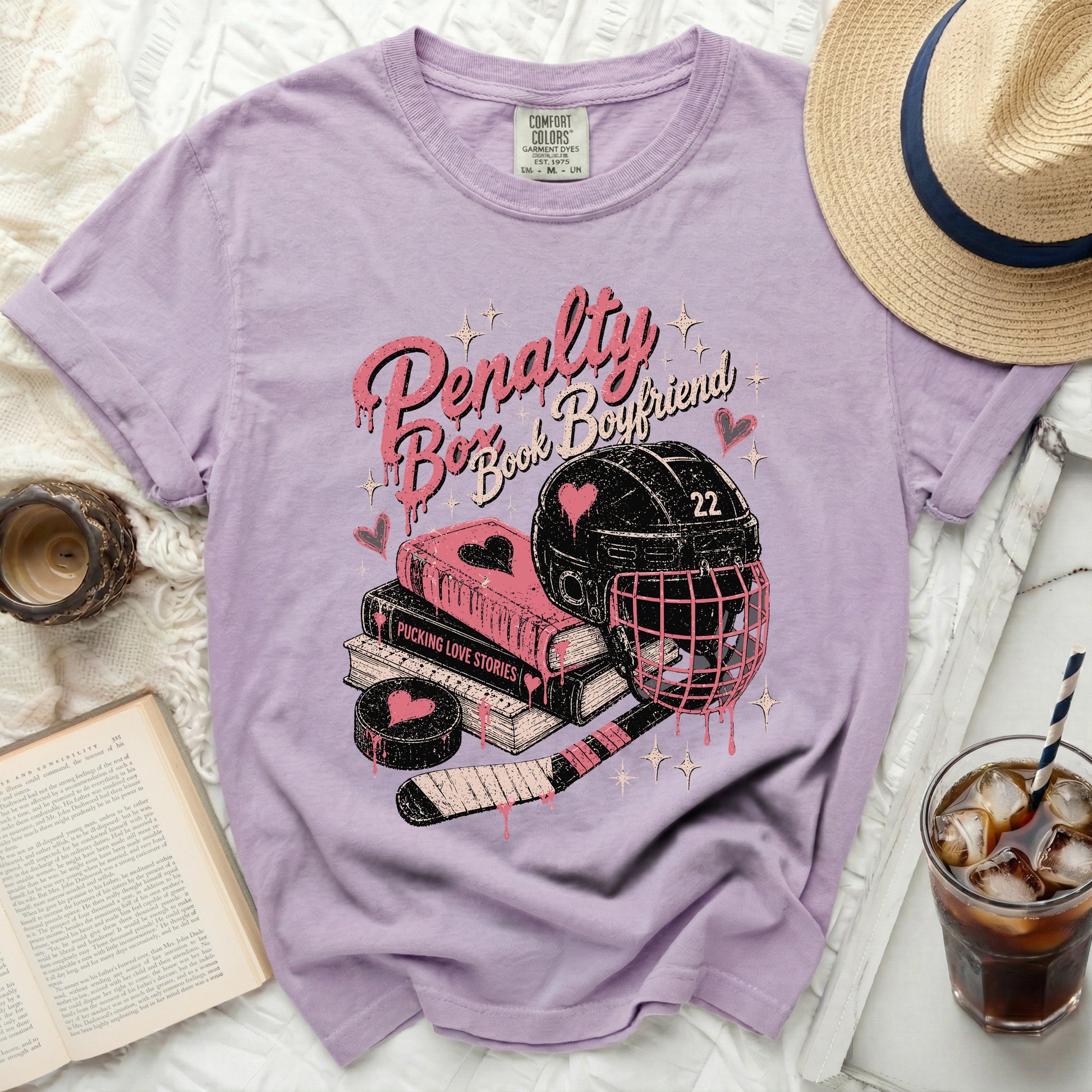 Purple t-shirt with hockey theme: helmet, puck, stick, and books.