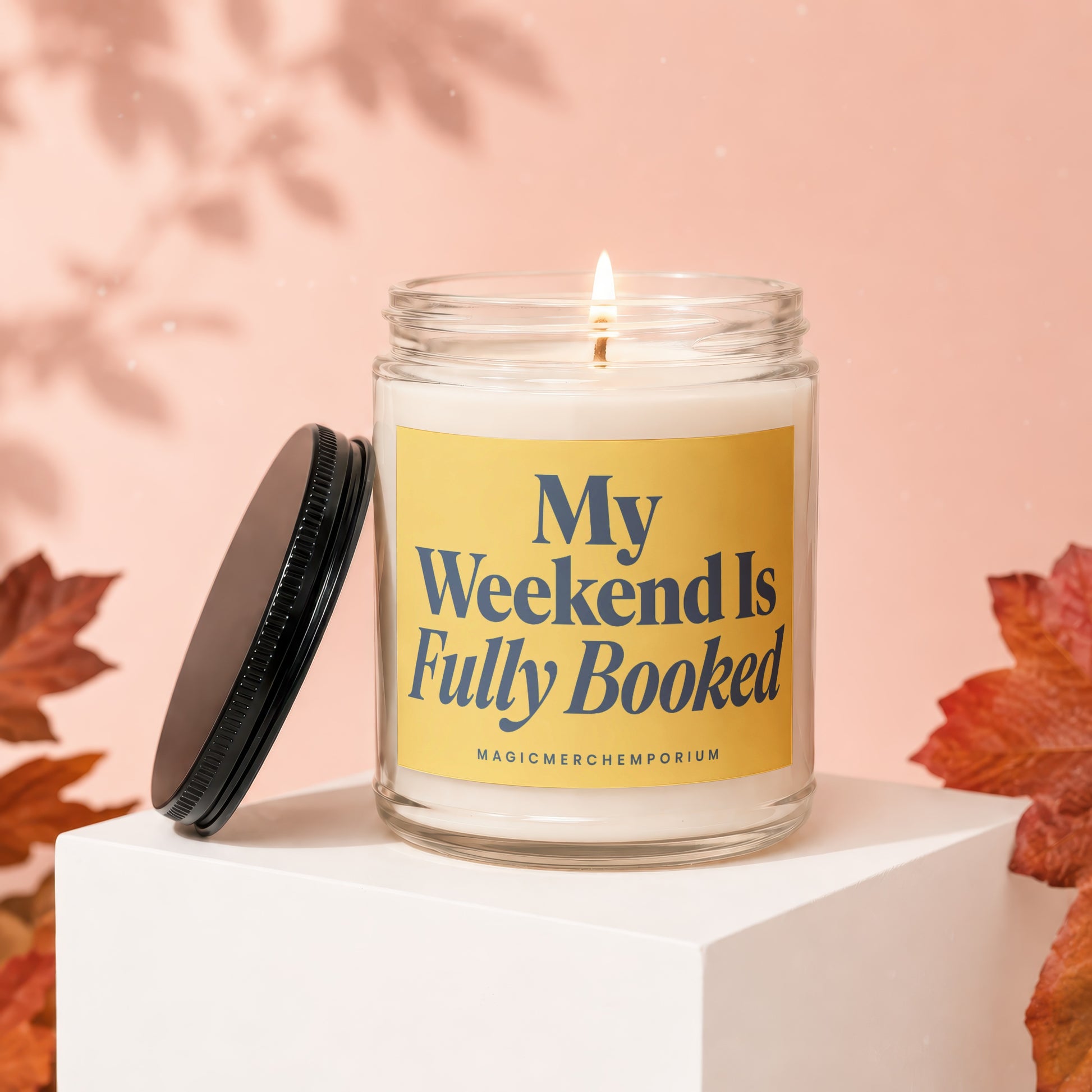 Glass candle with yellow label that reads "My Weekend Is Fully Booked".