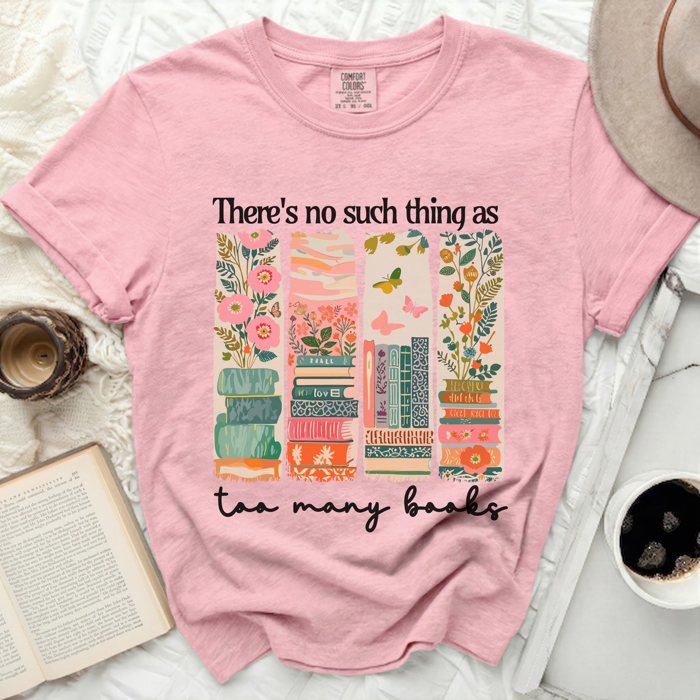 Pink t-shirt with stacked books and floral design.
