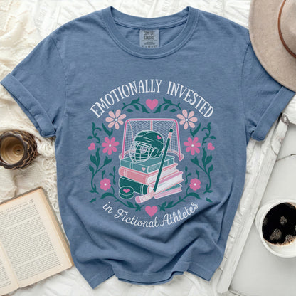Blue t-shirt with "Emotionally Invested in Fictional Athletes" text and hockey graphic.