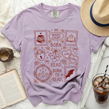 Purple t-shirt with red "Night Court Born to Read" stamp design and book motifs.