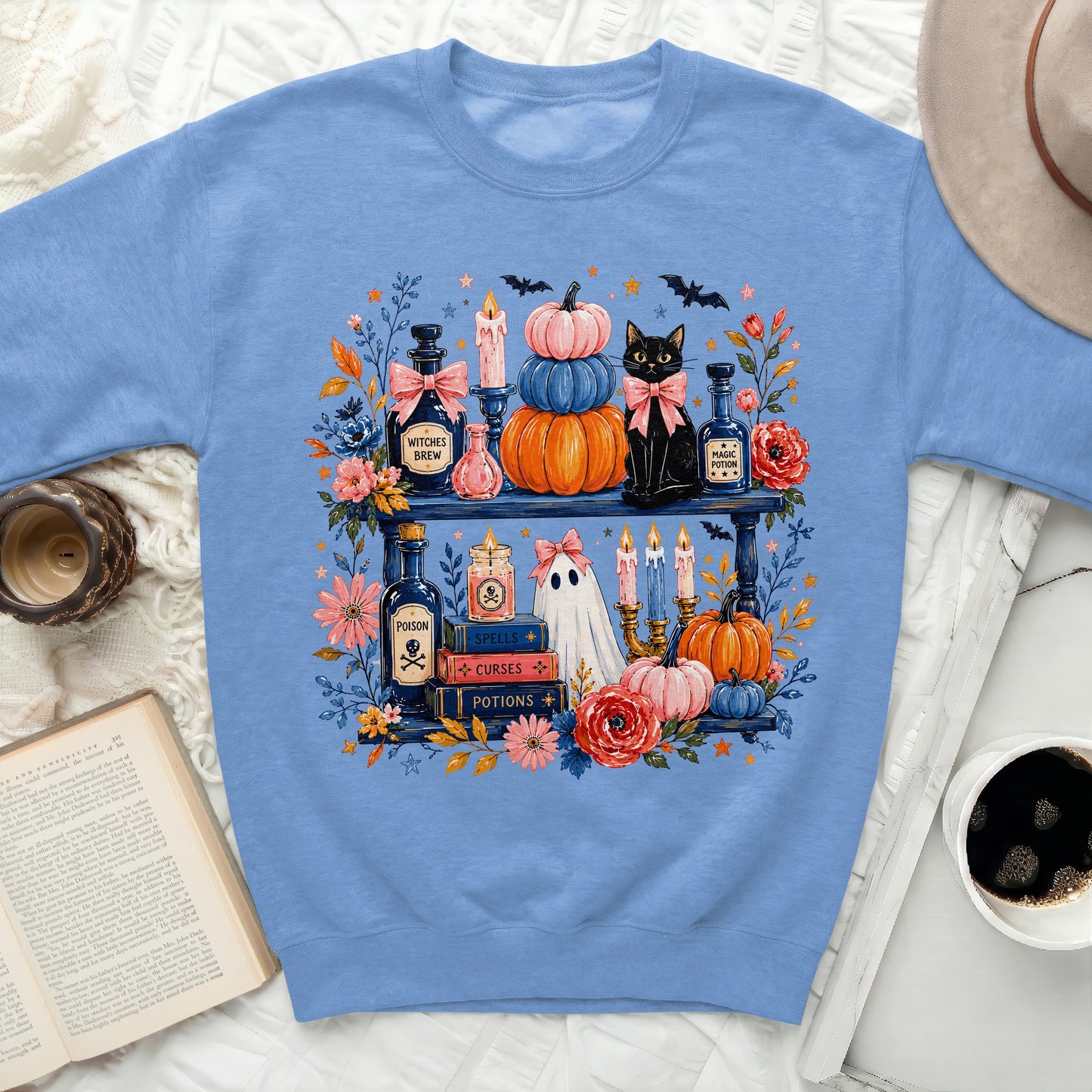 Light blue sweatshirt with Halloween-themed graphic of a black cat and potion bottles.