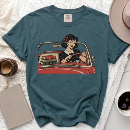 T-shirt with comic style print of woman driving convertible with books.